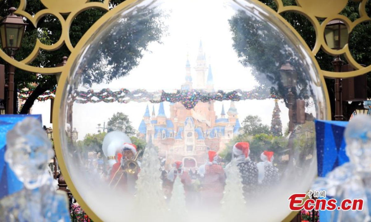 Staff members perform to welcome visitors in the Shanghai Disneyland, Dec 8, 2022. Photo:Xinhua