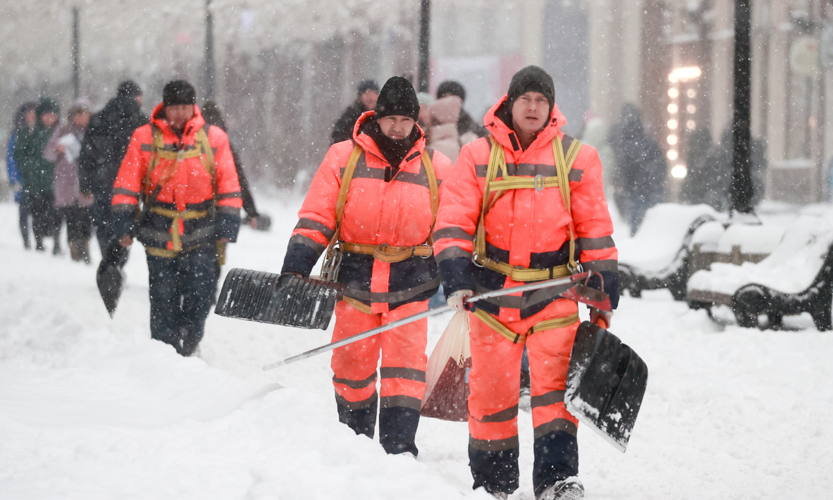 Utility workers are seen in Nikolskaya Street in Moscow, Russia during a snowfall on December 18, 2022. The Russian capital Moscow was hit by the heaviest snowfall in more than 80 years. Fifty flights were delayed and 13 were canceled at the capital’s airports. Photo: VCG