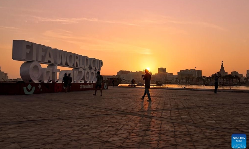 People take photos with the FIFA World Cup 2022 installations near the Doha Corniche in Doha, Qatar, on Nov. 11, 2022. (Xinhua/Xu Zijian)