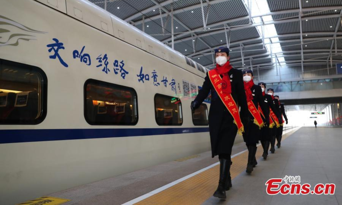 Staff members pose for a photo in front of the first train at the Yinchuan Railway Station in northwest China's Ningxia Hui Autonomous Region, Dec 29, 2022. Photo: China News Service