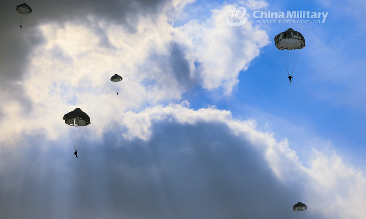 Airmen descend to the drop zone with their parachutes during a parachuting training exercise organized by an airborne brigade of the PLA Air Force on November 25, 2022. (eng.chinamil.com.cn/Photo by Yao Shiquan)