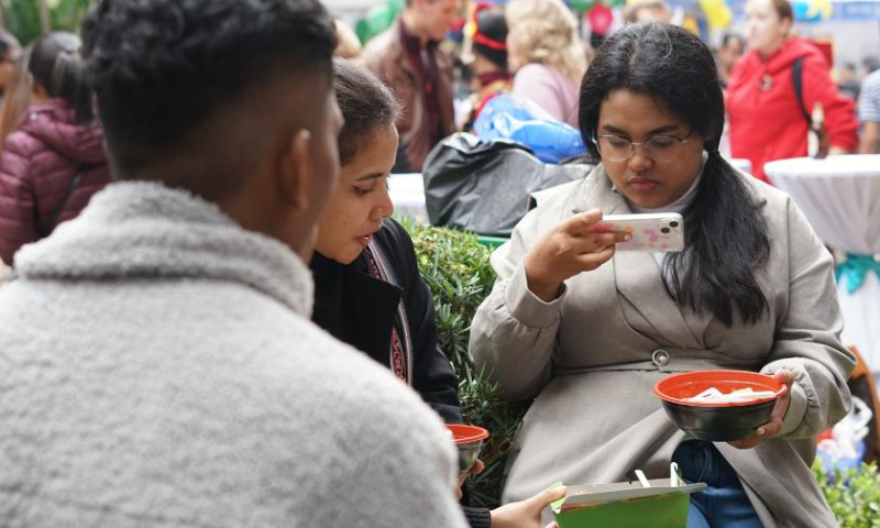 People enjoy food at the 2022 International Food Festival in Hanoi, Vietnam, on Dec. 11, 2022. The 2022 International Food Festival took place here on Sunday, featuring more than 100 booths with unique culinary experiences from different cultures. (Xinhua/Hu Jiali)