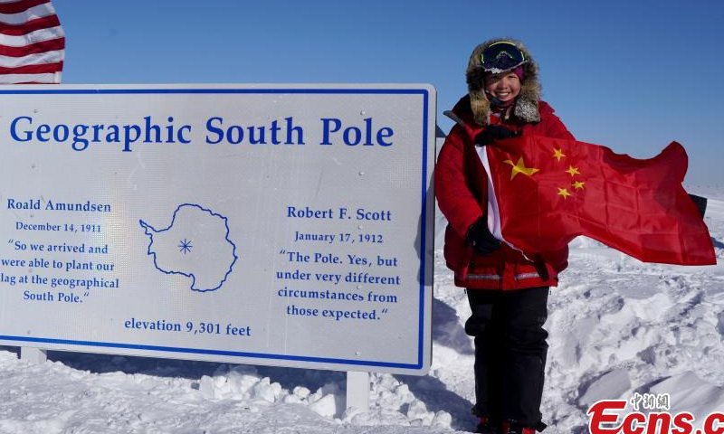 Chinese climber Han Zijun poses for photos beside a sign on the South Pole. (File photo provided to China News Service)