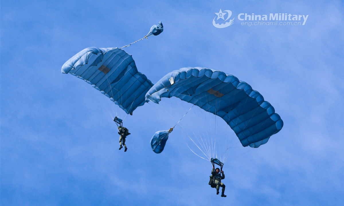 Airmen descend to the drop zone with their parachutes during a parachuting training exercise organized by an airborne brigade of the PLA Air Force on November 25, 2022. (eng.chinamil.com.cn/Photo by Yao Shiquan)