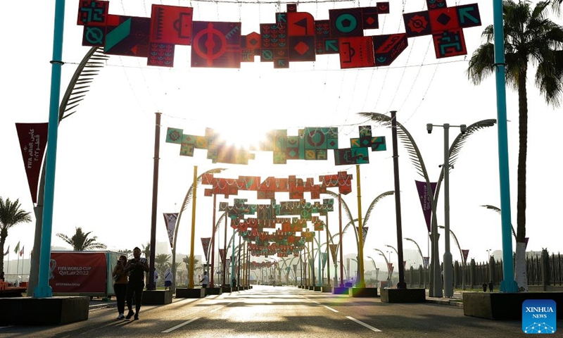 Pedestrians walk on the Doha Corniche with FIFA World Cup 2022 decorations in Doha, Qatar, on Nov. 11, 2022. (Xinhua/Xu Zijian)