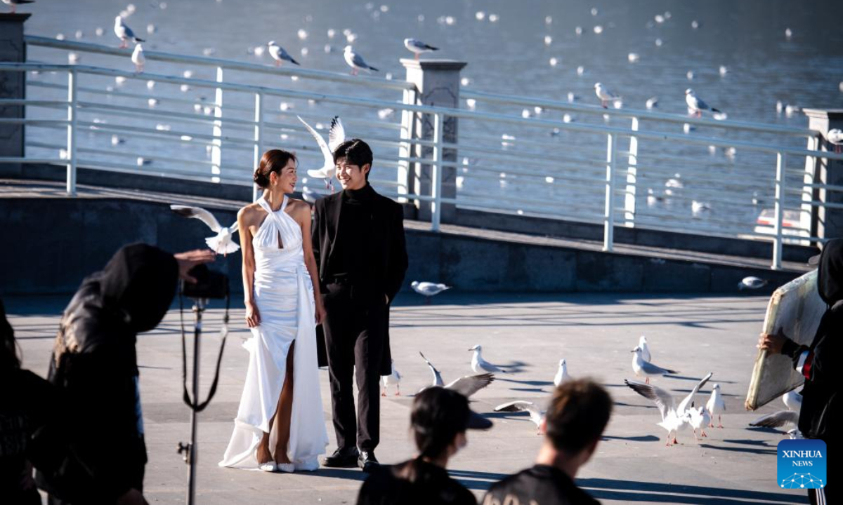 A couple take photos with black-headed gulls as the background by the bank of Dianchi Lake in Kunming, southwest China's Yunnan Province, Nov 17, 2022. Photo:Xinhua