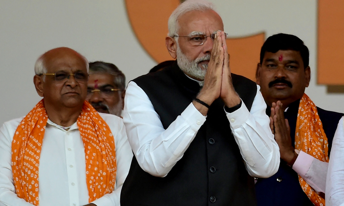 India's Prime Minister Narendra Modi (center) gestures during a swearing in ceremony of Gujarat Chief Minister Bhupendrabhai Patel (left) after Bharatiya Janata Party's (BJP) win in the Gujarat state assembly elections, in Gandhinagar, India on December 12, 2022. Photo: AFP