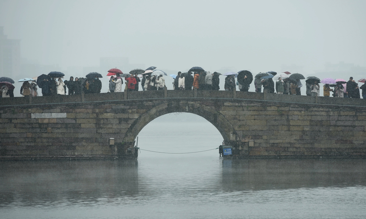 Residents in Hangzhou, East China's Zhejiang Province enjoy snow that is rare for this time of the year at the famous West Lake on December 1, 2022. A cold wave has swept most parts of China, dragging temperatures in Hangzhou below freezing. The city's average daily low temperature in December is usually 5 C. Photo: IC