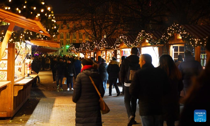 People visit the Christmas market beside the Red City Hall in Berlin, Germany, Nov. 22, 2022. (Xinhua/Ren Pengfei)