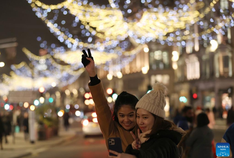 People take selfies on Oxford Street decorated with Christmas lights in central London, Britain, on Nov. 29, 2022. (Xinhua/Li Ying)