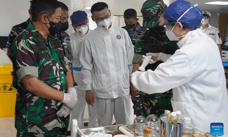 A doctor introduces acupuncture treatment and moxibustion treatment to Indonesian military health personnel on the Chinese naval hospital ship Peace Ark during a medical mission in Jakarta, capital of Indonesia, Nov. 11, 2022. Chinese naval hospital ship Peace Ark arrived at a military port in Zhoushan, east China's Zhejiang Province, on Tuesday morning after successfully completing a medical mission in Jakarta, capital of Indonesia.(Photo: Xinhua)