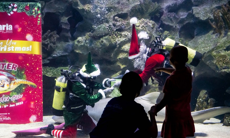 Divers dressed as Santa Claus and Elf perform during the Winter Wondersea event at Aquaria KLCC aquarium in Kuala Lumpur, Malaysia, Nov. 30, 2022.(Photo: Xinhua)