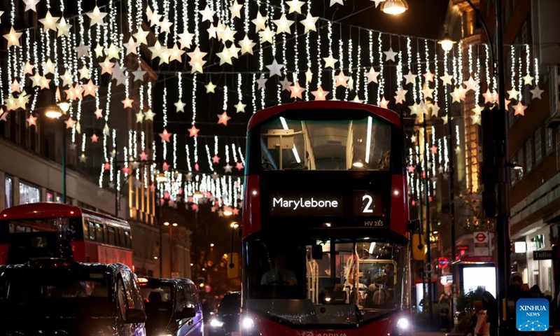 A double-decker bus runs on Oxford Street decorated with Christmas lights in central London, Britain, on Nov. 29, 2022.(Photo: Xinhua)