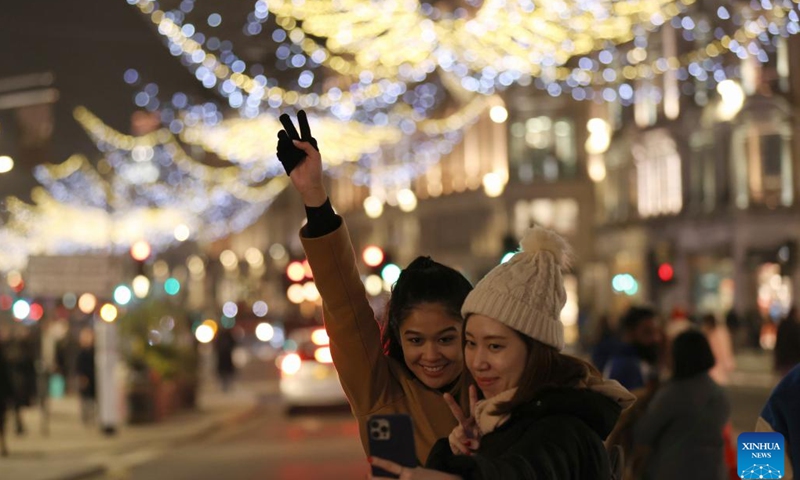 People take selfies on Oxford Street decorated with Christmas lights in central London, Britain, on Nov. 29, 2022.(Photo: Xinhua)