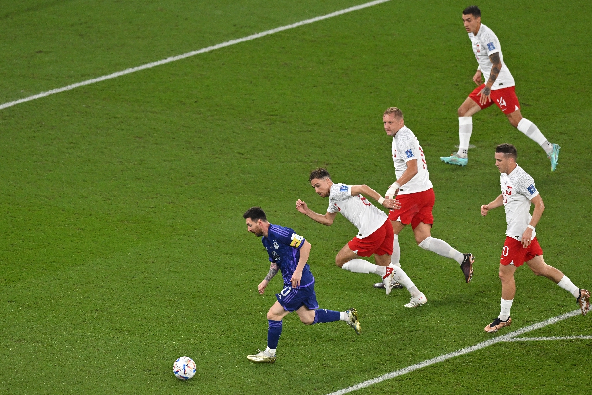 Argentina's Lionel Messi (left) leads the ball past Poland players during their World Cup Group C match in Doha, Qatar on November 30, 2022. Photo: AFP