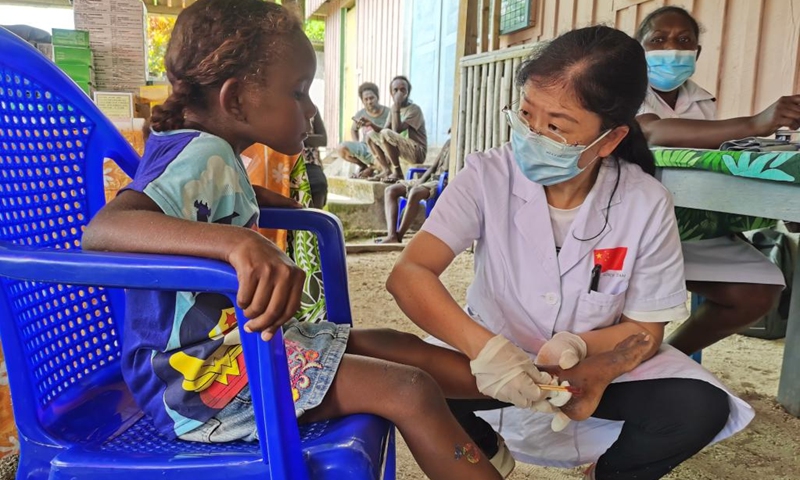 A doctor from the Chinese medical team provides free diagnosis and treatment service to a little girl in Gizo, capital of the Western Province, the Solomon Islands, Dec. 1, 2022. China's first medical team in the Solomon Islands on Wednesday provided free health services to people in Gizo, capital of the Western Province, which marked the third free clinical activity the team has conducted since its arrival in the country.(Photo: Xinhua)