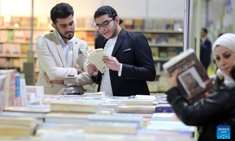 Visitors look at books at the Iraq International Book Fair in Baghdad, Iraq, on Dec. 7, 2022. Iraqi Prime Minister Mohammed Shia' al-Sudani on Wednesday opened the third edition of the Iraq International Book Fair that has attracted 350 Iraqi and foreign publishing houses from 20 countries.(Photo: Xinhua)