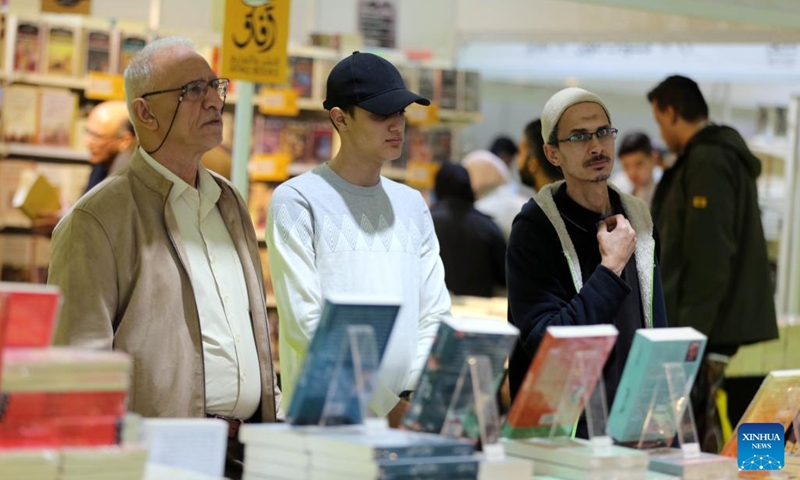 Visitors look at books at the Iraq International Book Fair in Baghdad, Iraq, on Dec. 7, 2022. Iraqi Prime Minister Mohammed Shia' al-Sudani on Wednesday opened the third edition of the Iraq International Book Fair that has attracted 350 Iraqi and foreign publishing houses from 20 countries.(Photo: Xinhua)