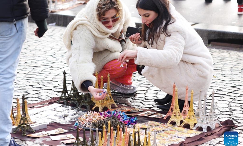 People purchase Eiffel Tower sculpture souvenirs at the Montmartre after snow in Paris, France, Dec. 14, 2022.(Photo: Xinhua)