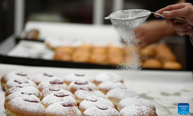 A bakery worker makes sufganiyot, round jelly donuts eaten during the Jewish festival of Hanukkah, at a bakery in Kiryat Shmona, northern Israel, on Dec. 14, 2022.(Photo: Xinhua)