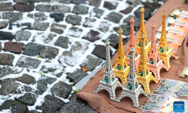 This photo taken on Dec. 14, 2022 shows the Eiffel Tower sculpture souvenirs sold by a street vendor at the Montmartre after snow in Paris, France.(Photo: Xinhua)