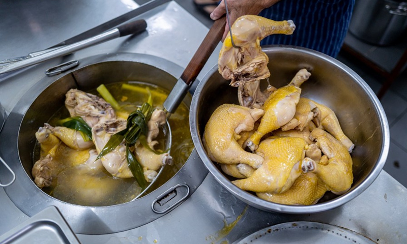 Andrew Wong Hin Hau prepares chicken for Hainan chicken rice in Kota Kinabalu in Sabah, Malaysia, Dec. 3, 2022.(Photo: Xinhua)