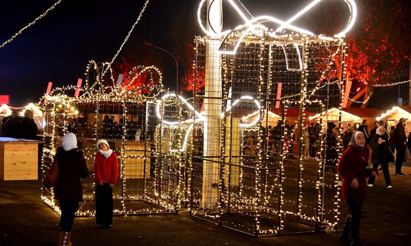 Syrians attend a Christmas Market set up in Damascus, the capital of Syria, on Dec. 15, 2022. The market constitutes more than 75 wooden huts set up recently to display Christmas decorations, gifts, food, and celebratory activities during the holiday season.(Photo: Xinhua)