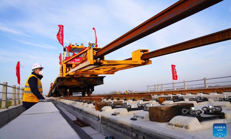 Workers lay tracks at the construction site of the Jinan-Zhengzhou high-speed railway in Liaocheng City, east China's Shandong Province, Dec. 15, 2022. The track-laying ceremony of the Shandong section of Jinan-Zhengzhou high-speed railway was held in Liaocheng City on Thursday.(Photo: Xinhua)