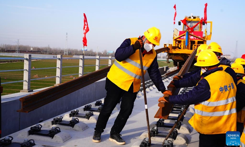 Workers lay tracks at the construction site of the Jinan-Zhengzhou high-speed railway in Liaocheng City, east China's Shandong Province, Dec. 15, 2022. The track-laying ceremony of the Shandong section of Jinan-Zhengzhou high-speed railway was held in Liaocheng City on Thursday.(Photo: Xinhua)