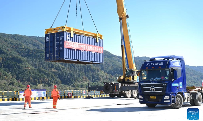 A staff member lifts a container with a crane at a wharf of Nanping Port in southeast China's Fujian Province on Dec. 18, 2022. The main stream of Minjiang River reopened to navigation on Sunday. Navigation in the river's main stream had been suspended for years due to changes in water level and hydrogeological conditions.(Photo: Xinhua)