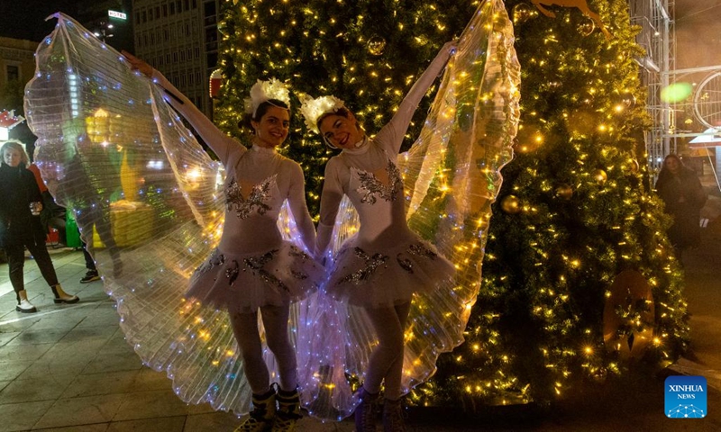 Two girls dressed as fairies pose by a Christmas tree in Athens, Greece, on Dec. 18, 2022.(Photo: Xinhua)