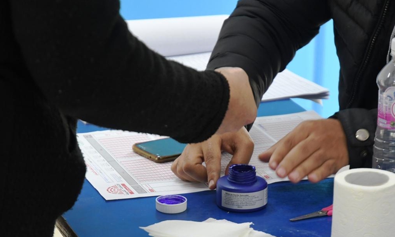 A voter (L) registers at a polling station in Tunis, Tunisia on Dec. 17, 2022. Tunisians on Saturday started voting in legislative elections, with a total of 4,551 voting centers and 11,310 polling stations open in the Tunisian territory, the Independent High Authority for Elections (ISIE) said. (Photo by Adel Ezzine/Xinhua)