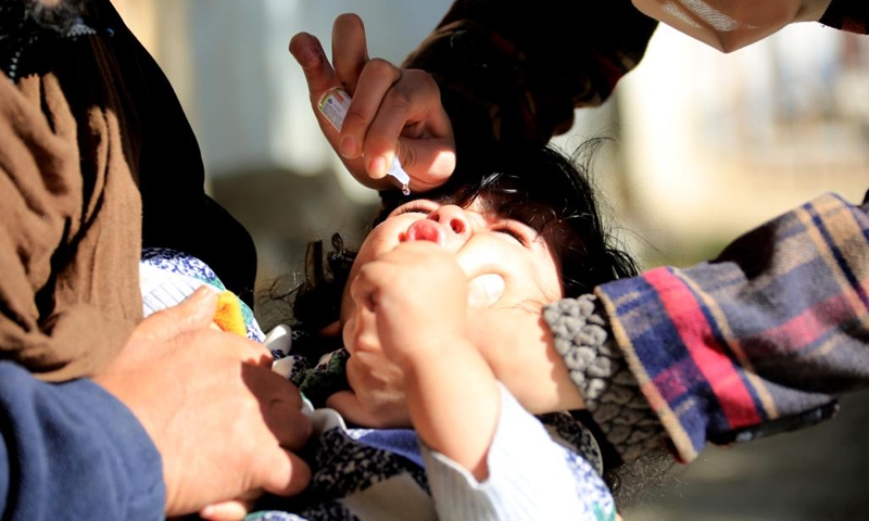 A health worker gives a dose of the polio vaccine to a child during a vaccination campaign against polio in Kabul, Afghanistan, Dec. 21, 2022. Afghanistan's Ministry of Public Health has launched a campaign to vaccinate around 7 million children under five against polio, said a statement released by the ministry on Tuesday.(Photo: Xinhua)