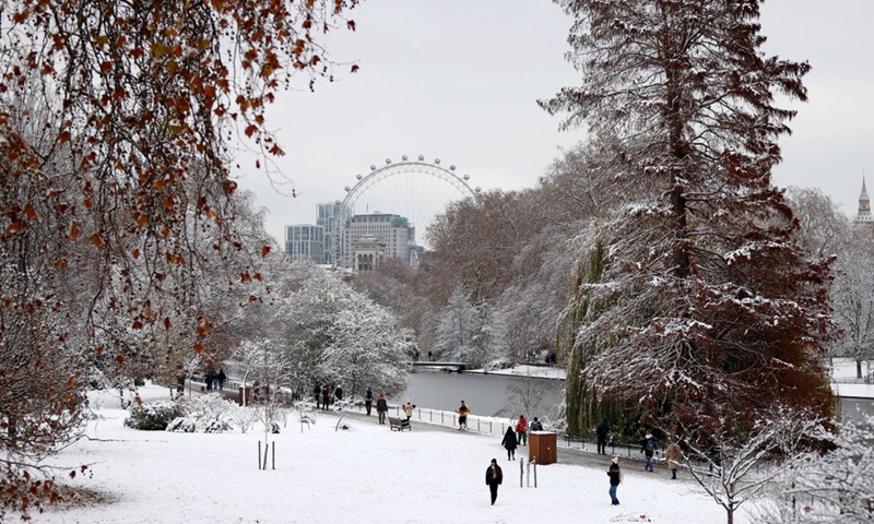 People walk in the snow near the London Eye in London, Britain, Dec. 12, 2022.(Photo: Xinhua)