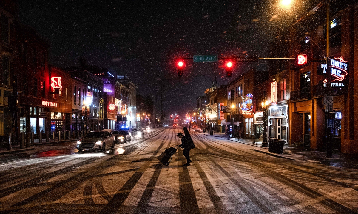 A musician departs following a show on Broadway, a popular tourist street in Nashville, Tennessee, on December 22, 2022. A once-in-a-generation winter storm with temperatures as low as -40 degrees Celsius caused Christmas travel chaos in the US on Thursday, with thousands of flights cancelled and major highways closed. Photo: VCG