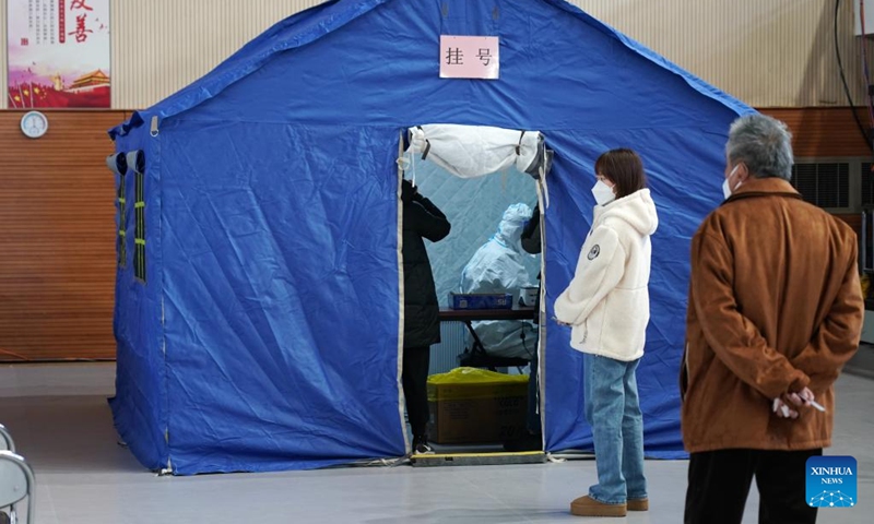 People line up to seek medical advice in a makeshift fever clinic in Guang'an Gymnasium in Beijing, capital of China, Dec. 24, 2022. In order to facilitate fever patients to seek medical treatment and ensure residents' medical needs, some hospitals in Beijing set up makeshift fever clinics in gymnasiums to provide services such as diagnosis, prescription issuing and medicine dispensing for citizens. (Xinhua/Zhang Chenlin)