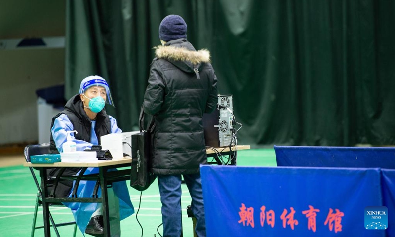 A medical worker gives medical advice to a citizen in a makeshift fever clinic of Beijing Chaoyang Hospital in Chaoyang Gymnasium in Beijing, capital of China, Dec. 24, 2022. In order to facilitate fever patients to seek medical treatment and ensure residents' medical needs, some hospitals in Beijing set up makeshift fever clinics in gymnasiums to provide services such as diagnosis, prescription issuing and medicine dispensing for citizens. (Xinhua/Chen Zhonghao)