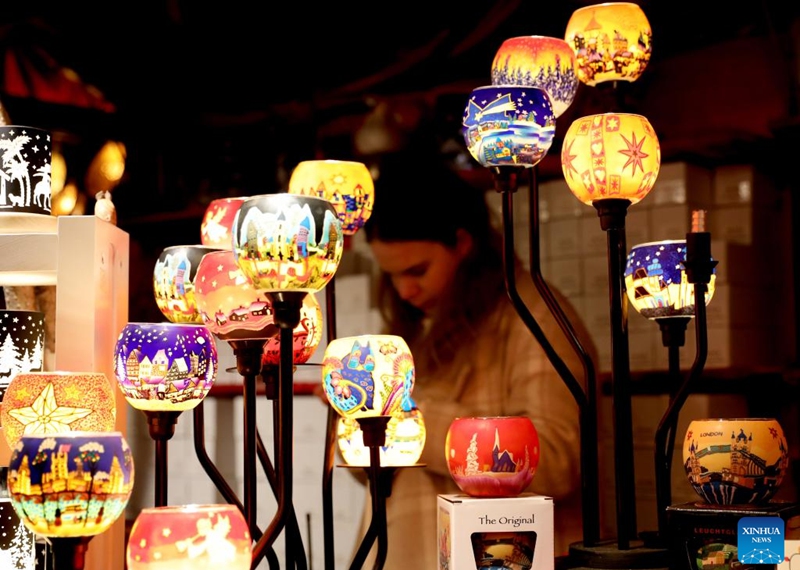 A woman sells lights at Hyde Park Winter Wonderland on Christmas Eve in London, Britain, Dec. 24, 2022. (Xinhua/Li Ying)