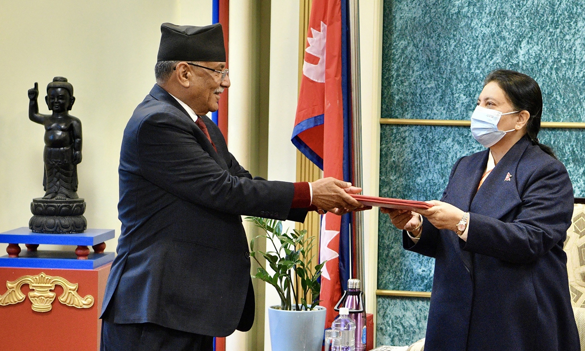 Nepal's former guerrilla leader Pushpa Kamal Dahal (left) hands over his documents to President Bidya Devi Bhandari to claim majority for his appointment as the new prime minister, at the president's office in Kathmandu, Nepal on December 25, 2022. Photo: AFP