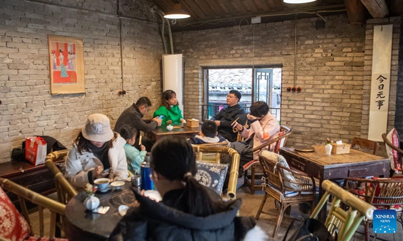 Tourists chat at a teahouse at Shancheng Alley of the Jiefangbei business district in Chongqing, southwest China, on Dec. 24, 2022. (Xinhua/Tang Yi)