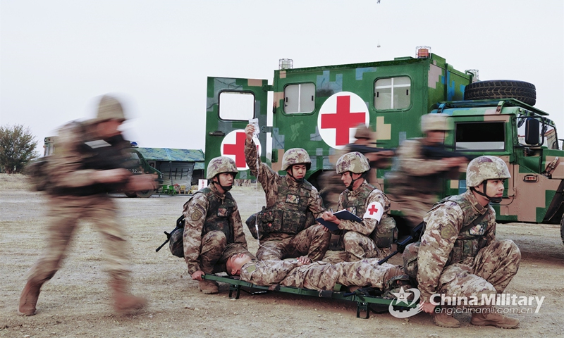 Medics assigned to a combined-arms brigade with the army under the PLA Central Theater Command give first aid treatment to and transfer the wounded during a real combat medical support training exercise on November 28, 2022. (eng.chinamil.com.cn/Photo by Yan Qizhao)