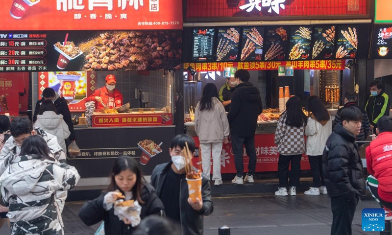 People buy snacks at the Jiefangbei business district in Chongqing, southwest China, on Dec. 23, 2022. (Xinhua/Tang Yi)