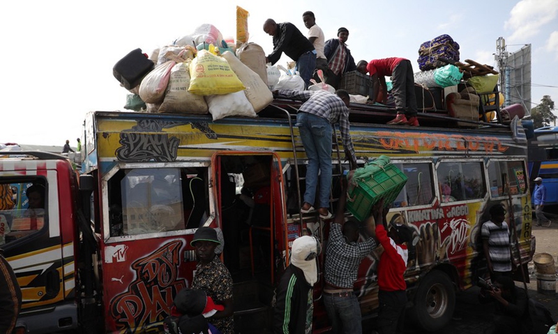 Matatu operators load goods and items of passengers traveling to upcountry areas for the festive season in Nairobi, Kenya, Dec. 20, 2022. (Photo by Fred Mutune/Xinhua)