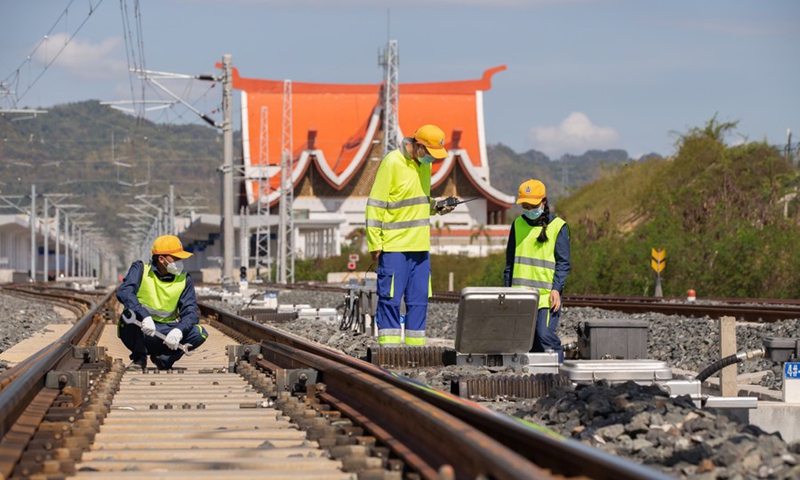 Chinese and Lao staff members maintain the railway in Luang Prabang, Laos, Dec. 1, 2022.(Photo by Kaikeo Saiyasane/Xinhua)