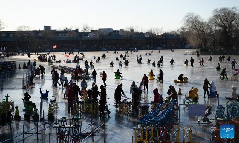 People play on the frozen Shichahai lake which has been turned to an ice rink in Beijing, capital of China, Dec. 27, 2022. The ice rink opened to the public on Tuesday.(Photo: Xinhua)