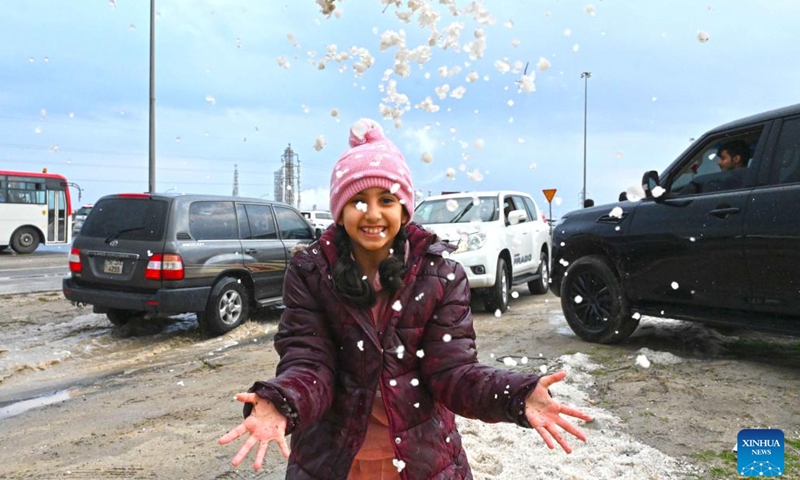 A girl plays with hailstones in Ahmadi Governorate, Kuwait, on Dec. 27, 2022. Hail lashed a number of areas in Kuwait on Tuesday.(Photo: Xinhua)