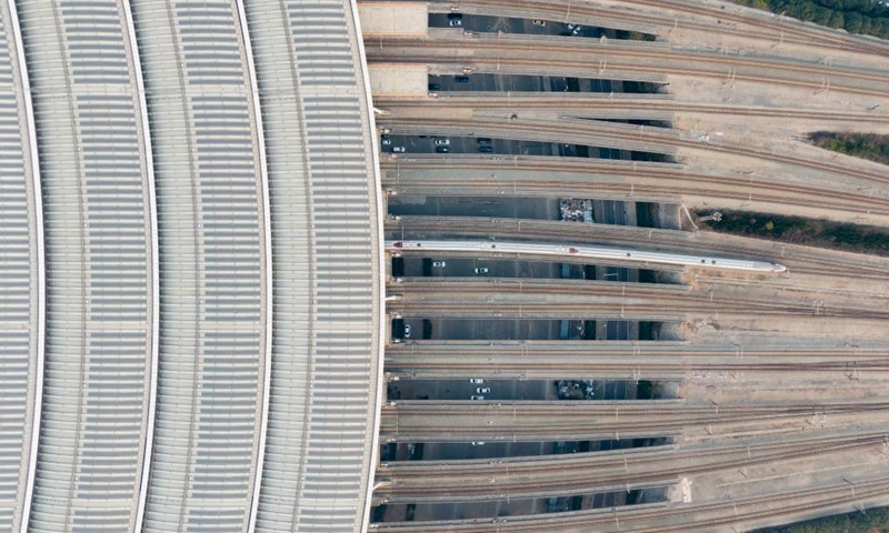 This aerial photo taken on Dec. 26, 2022 shows a bullet train departing from Wuhan Railway Station in Wuhan, central China's Hubei Province. A total of 1.69 billion passenger trips have been made on the Beijing-Guangzhou high-speed railway since it went into operation ten years ago, official data showed.(Photo: Xinhua)