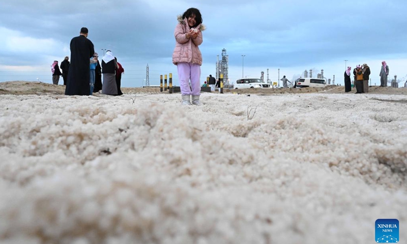 A girl holds hailstones in Ahmadi Governorate, Kuwait, on Dec. 27, 2022. Hail lashed a number of areas in Kuwait on Tuesday.(Photo: Xinhua)