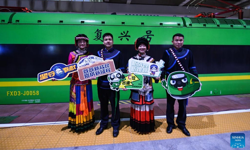 People of Yi ethnic group pose for a group photo before the departing of a Fuxing bullet train coded C57 on the new Chengdu-Kunming Railway at Chengdu South Railway Station in Chengdu, southwest China's Sichuan Province, Dec. 26, 2022. A railway linking Chengdu and Kunming, two major cities in southwest China, is now fully operational with the opening of its last section on Monday.(Photo: Xinhua)