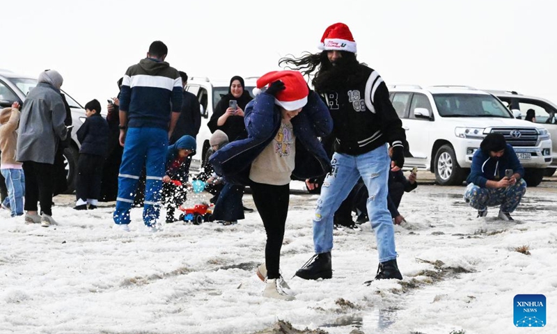 People play with hailstones in Ahmadi Governorate, Kuwait, on Dec. 27, 2022. Hail lashed a number of areas in Kuwait on Tuesday.(Photo: Xinhua)